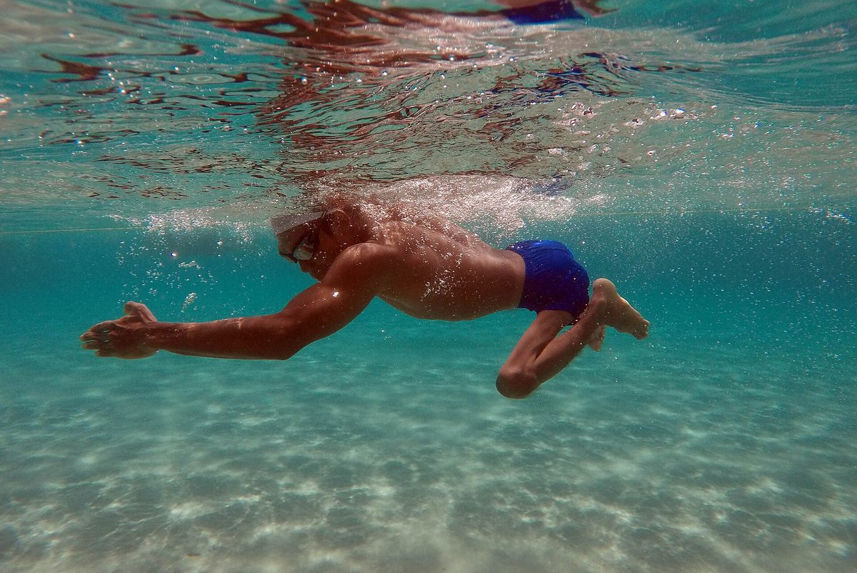 A para swimmer at the edge of a competition pool.