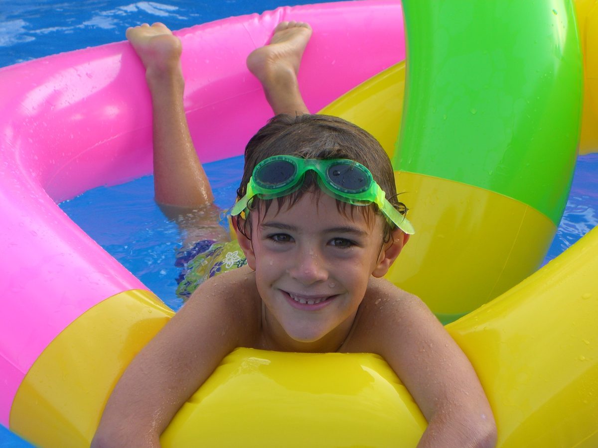 Swimmers enjoying a busy public swimming pool.